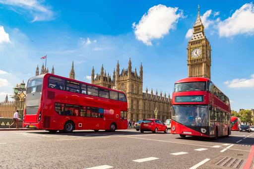 Two red double-decker buses on a street with Big Ben and the Palace of Westminster in the background.